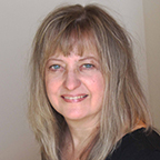 headshot of a smiling woman with light, shoulder-length hair and wearing a black top.