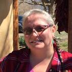 headshot of a woman in braids and glasses. she is wearing a red flannel